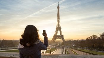 Woman photographing the Eiffel tower, Paris